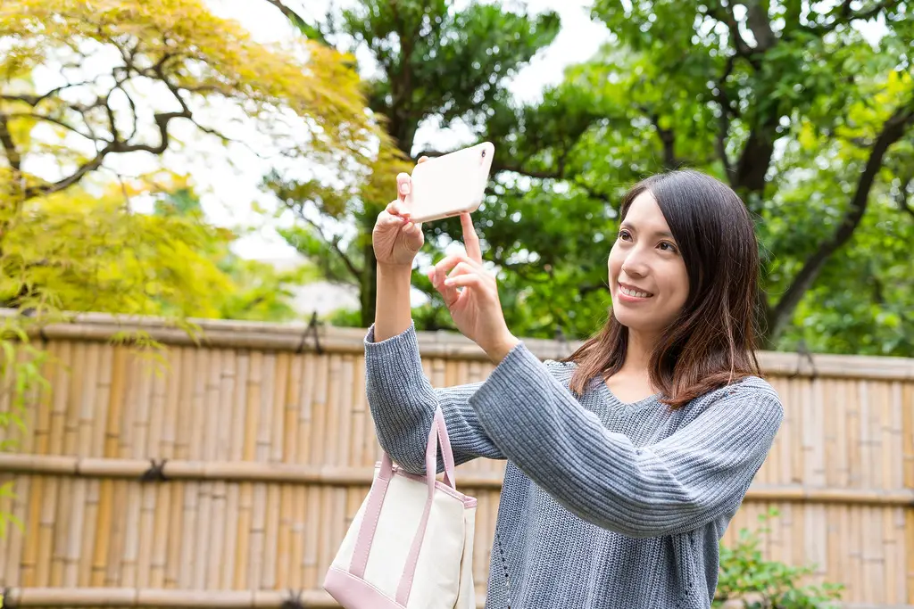 Woman taking photo by mobile phone